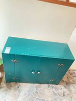 front top view of green cabinet showing knobs and hinges