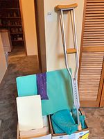 Overall view of lot showing wedge pillow, crutches, two boxes of towels and mats