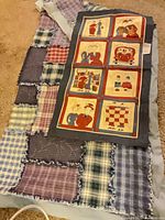 Quilt and tapestry laid out together, showing overall patterns and scale