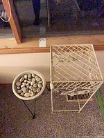 Top view of both plant stands; black tripod stand with dish and rocks, cream rectangular stand