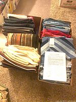 Four small boxes filled with folded fabric pieces of various colours and materials