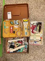 Open plastic sewing basket, clear bin and cardboard flat with trims