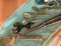Mixed flatware including forks, knives, spoons on cloth