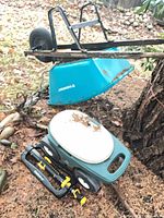 Wheelbarrow, sprinkler and garden seat together outdoors