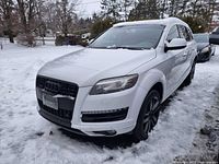Front three-quarter view showing grille, headlights, license plate area, snow-covered body