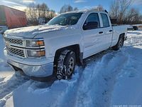Front three-quarter driver side view of white 2016 Chevrolet Silverado LT in snow