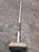 Full view of Brownie curling broom on concrete floor