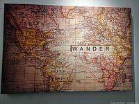 Full view of printed canvas showing world map and "WANDER" text
