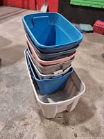 Stacked view of all eight plastic totes showing colors and sizes