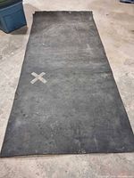 Full view of unrolled rubber flooring showing width and surface condition