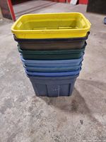 Stack of seven Rubbermaid bins in various colours