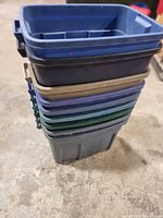 Stack of nine plastic bins in assorted colours