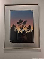 Framed serigraph showing sunset scene