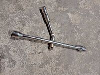 Full view of chrome 3-way lug wrench showing three socket ends