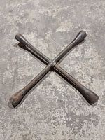 Full view of tire iron showing cross shape and all four socket ends