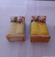 Top view of both ceramic mice-in-bed figurines showing design and glaze