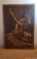Full view of hammered copper plaque showing Indigenous archer scene and border