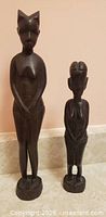 Front view of both wood fertility statues upright
