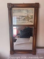 Front view of framed mirror showing lithograph and turned spindle frame