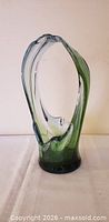 Front view of green clear hand blown stretch art glass basket showing pulled handle and color gradient