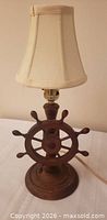 Full view of lamp showing wood ship’s wheel base and fabric shade