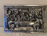 Front view of silver-plated repoussé Last Supper plaque showing detailed relief and inscription