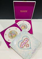 Both plates displayed in open presentation boxes.