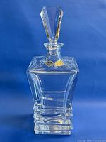 Front view of crystal decanter with stopper and labels visible