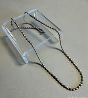 Chain displayed on clear stand showing bead style and clasp