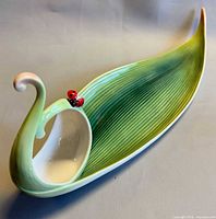 Overall view of Franz porcelain leaf candy dish showing bird handle and ladybug