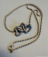 Necklace laid flat showing clasp, chain style and pendant