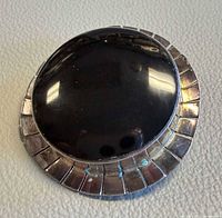 Front view showing onyx cabochon and silver border