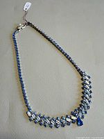 Full view of blue rhinestone choker on neutral surface