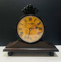 Front view of T. Revere double-sided mantel clock on wood base