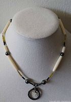 Full view of choker on display form showing bead pattern and pendant