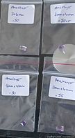 Overview of all four bagged amethyst stones with handwritten size/weight labels visible