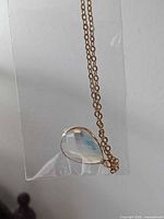 Sealed necklace with clear faceted teardrop stone and gold chain