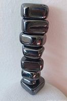 Stack of eight polished magnetic hematite stones showing size variation