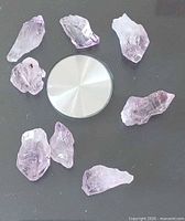 Eight amethyst crystal points arranged around a circular object