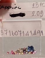 Bag containing 25 multicoloured faceted sapphires with handwritten weight and count