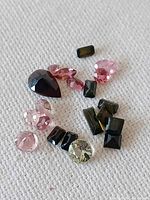 Assorted loose tourmalines on fabric showing colour variety