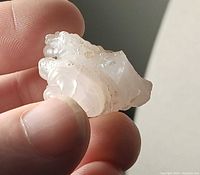 Close-up of chalcedony nodule held between fingers