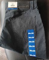 Folded black pants with back pocket and size stickers 36x30