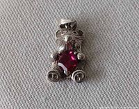 Front view of sterling silver bear pendant showcasing pink heart crystal and textured detailing