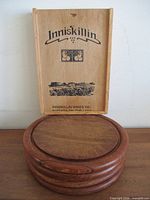 Inniskillin printed sliding box on top of stacked round wooden boards