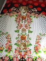 Full length view of patterned fabric unrolled showing classical head, florals, polka dots