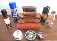 All items arranged on table showing variety of shoe care products and brushes
