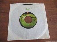 Front of 45 rpm record in Apple sleeve, B-side visible