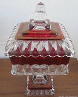 front view of lidded square pedestal candy dish showing ruby flash band and finial