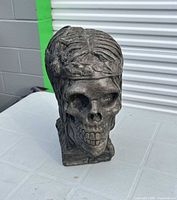 Front view of concrete skull head sculpture